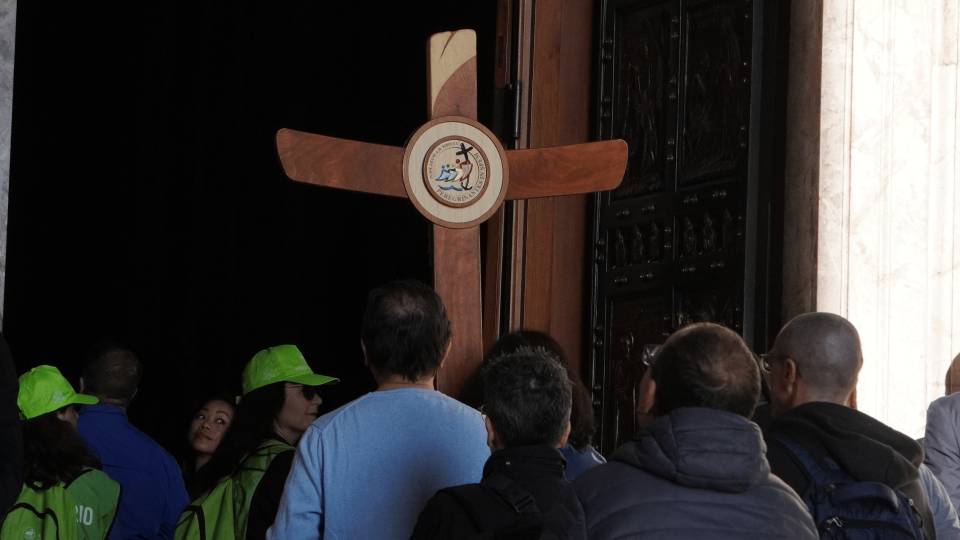 Com a cruz jubilar, peregrinos passam pela Porta Santa da Basílica de São Pedro / Foto: Joyce Mesquita
