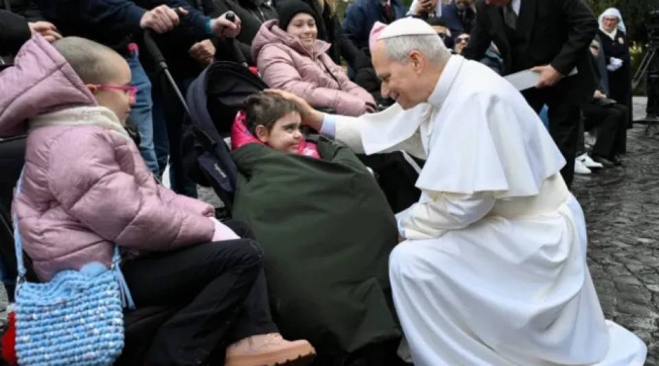 Papa Leão XIV cumprimenta uma das crianças doentes aos pés de Nossa Senhora de Lourdes nos Jardins do Vaticano | Crédito: Vatican Media